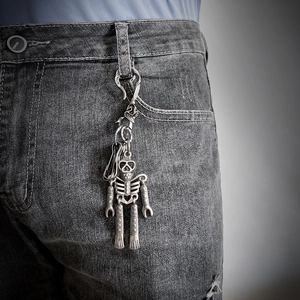 Gothic skull pendant keychain with movable limbs in vintage silver hanging on jeans