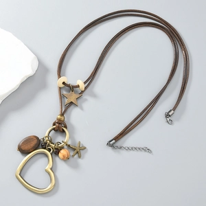 Collier cœur bohème avec métal bronze et perles en bois sur cordon tressé
