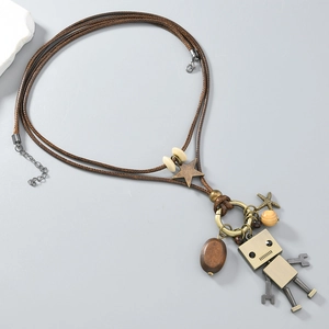 Detail of vintage long necklace featuring a movable robot pendant and bronze charms