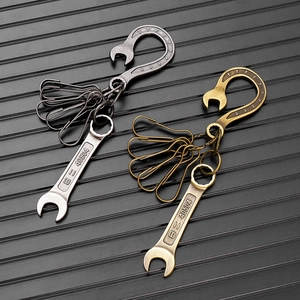Macro shot of industrial vintage wrench keychain in silver and bronze metal finishes