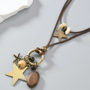 Detail der Vintage-Sternkette mit Bronze-Anhängern und dunklem Holzelement-Anhänger