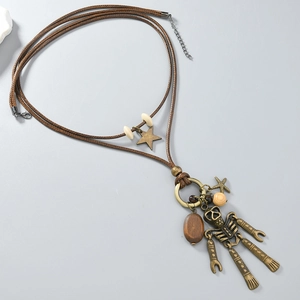 Detailed macro view of vintage bronze skull pendant and star charms on beaded cord