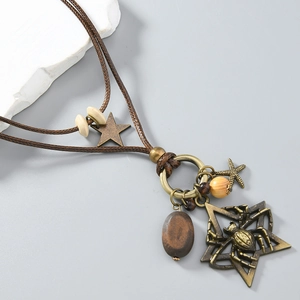 Detailed macro view of vintage bronze spider pendant with layered woven leather cord