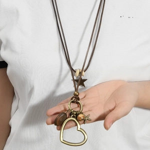 Long collier bohème avec pendentifs cœur en bronze et perles en bois marron