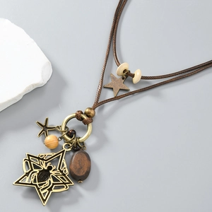 Close-up of vintage spider pendant with ethnic wooden beads on long woven cord