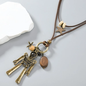 Close-up of retro bronze robot pendant with wooden beads and stars on woven cord