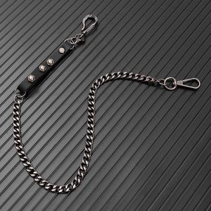 Close-up of punk style trousers chain with silver Cuban links and skull hook detail