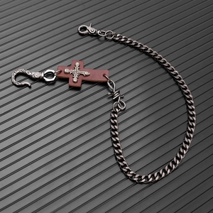 Detail of gothic punk metal wallet chain with leather cross and ornate vintage hook