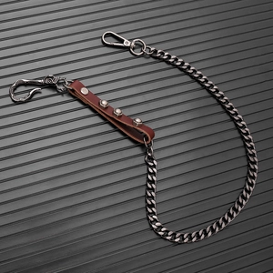 Macro shot of punk hip-hop wallet chain with brown leather strap and silver studs