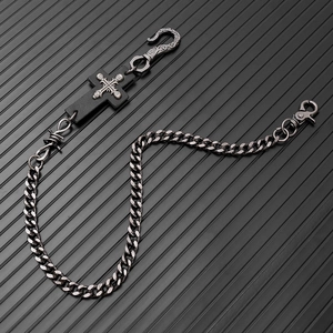 Detail of punk style gothic trousers chain with cross skull and gunmetal curb links