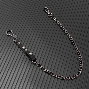 Detail of punk metal trouser chain with black leather rivet strap and ornate S-hook