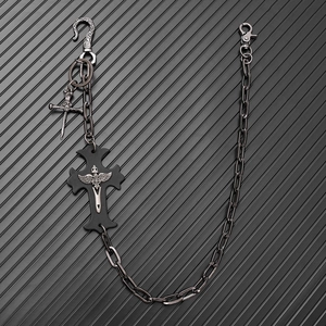 Close-up of punk style trousers chain featuring black cross pendant and gothic metal sword