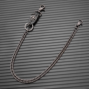 Detail of dark gunmetal curb chain trouser link with gothic skull leather attachment