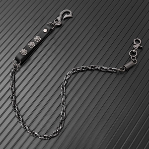 Close-up of punk style metal trousers chain with black leather and relief carved buckle