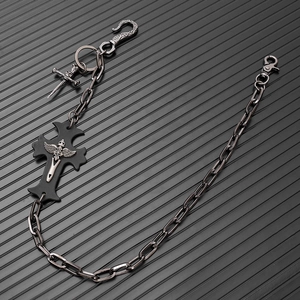 Detail of gothic punk metal wallet chain featuring a cross pendant with wing sword relief