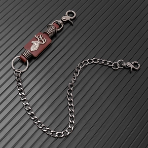Close-up of punk style wallet chain with vintage deer head embossed on leather patch