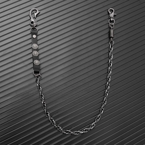 Detail of punk style metal chain featuring black leather strap and floral embossed studs