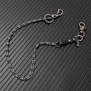 Macro view of vintage silver pant chain featuring industrial hook and lobster clasp details