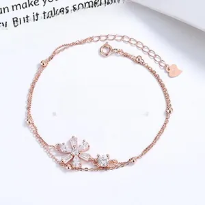 Detail eines S925 Silber Roségold Doppelarmbands mit Zirkonia-Blume und Herz-Anhänger