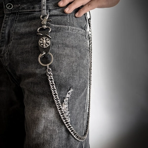 Punk silver skull trouser chain with leather embossed medallion on denim jeans