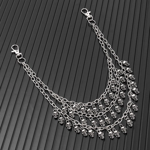 Close-up of multilayer silver metal pant chain featuring detailed skull charms and lobster clasps