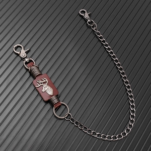 Detail view of retro silver metal chain with dark brown leather and stag embossment