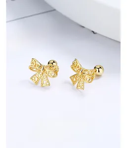 Detailed macro view of gold bow earrings with hollow heart pattern and screw back closure