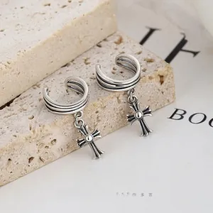 Gros plan sur une boucle d'oreille triple épaisseur en argent 925 avec croix vintage