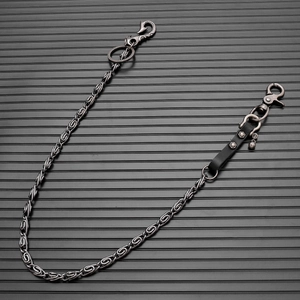 Detail of dark grey punk waist chain with leather rivet strap and skull pendant charm
