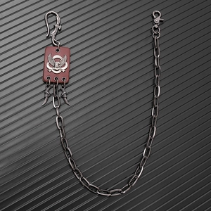 Detail of punk eagle crest leather patch and metal fangs on a hip-hop style trousers chain