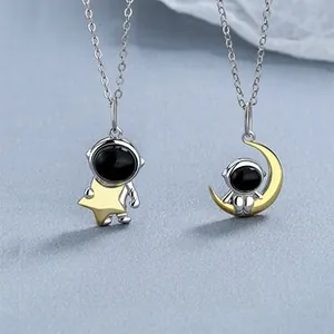 Detail of astronaut couple pendants featuring star and crescent moon in S925 silver