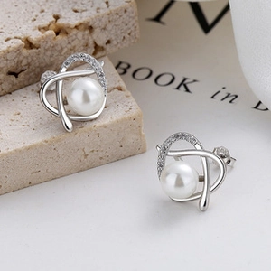 Détail de boucles d'oreilles en argent 925 avec perles blanches et zircons scintillants