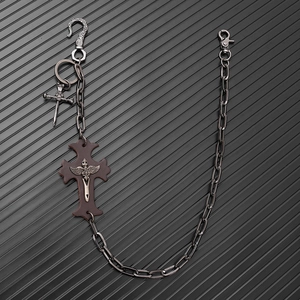Detail of punk metal trouser chain with leather cross and skull charms for denim wear