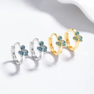 Detailed macro of enamel iris flower earrings in silver and gold with zircon centers