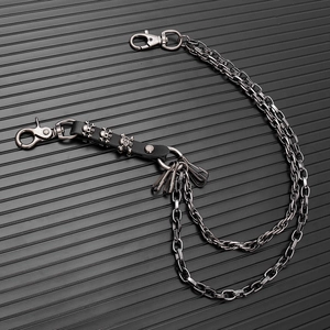 Detail of layered metal waist chain with skull rivets on black leather and lobster clasps