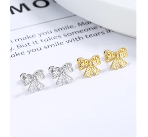 Detail view of hollow bow earrings with heart patterns in gold and silver finishes