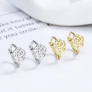 Macro shot of 925 sterling silver hollow camellia earrings in silver and gold finishes