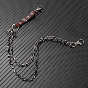 Detail of a double-layered punk waist chain featuring skull leather accents and lobster clasps
