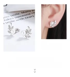 Détail de boucles d'oreilles feuille d'olivier en argent 925 avec perle et éclats
