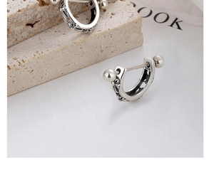 Dettaglio macro dell'orecchino a C in argento sterling S925 con incisioni gotiche