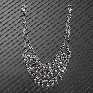 Detail of multi-layer metal trousers chain with skull pendants and lobster clasps in punk style