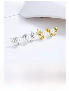 Vue macro des boucles d'oreilles feuille d'olivier en argent 925 avec perles et détails