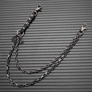 Macro shot of multi-layer metal waist chain with skull charms and leather straps