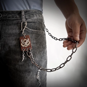 Detail of hip hop eagle pendant waist chain with dark leather and metallic eagle claw