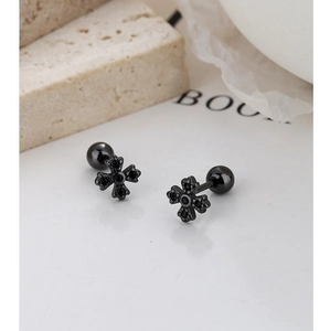 Détails macro de boucles d'oreilles croix gothiques noires serties de zircons noirs