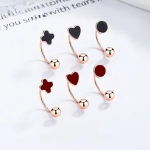 Détail de boucles d'oreilles créoles trèfle et cœur en émail or rose sur fond blanc