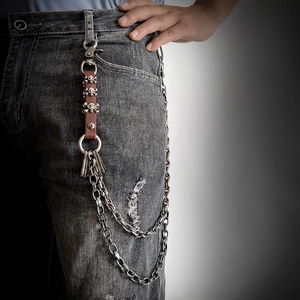 Punk style multilayer waist chain with silver skull metal charms and leather strap on jeans