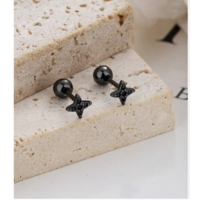 Vue macro des boucles d'oreilles étoile à quatre branches noires avec fermoir à vis