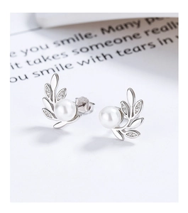 Détail macro de boucles d'oreilles feuilles d'olivier en argent 925 avec perle