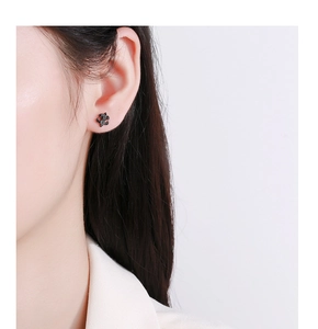 Vue rapprochée d'une boucle d'oreille puzzle noire sertie de pierres sur l'oreille